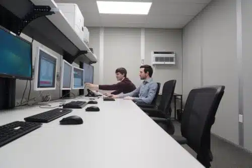 Two engineers in office inspecting monitor with spin or balance test results on it